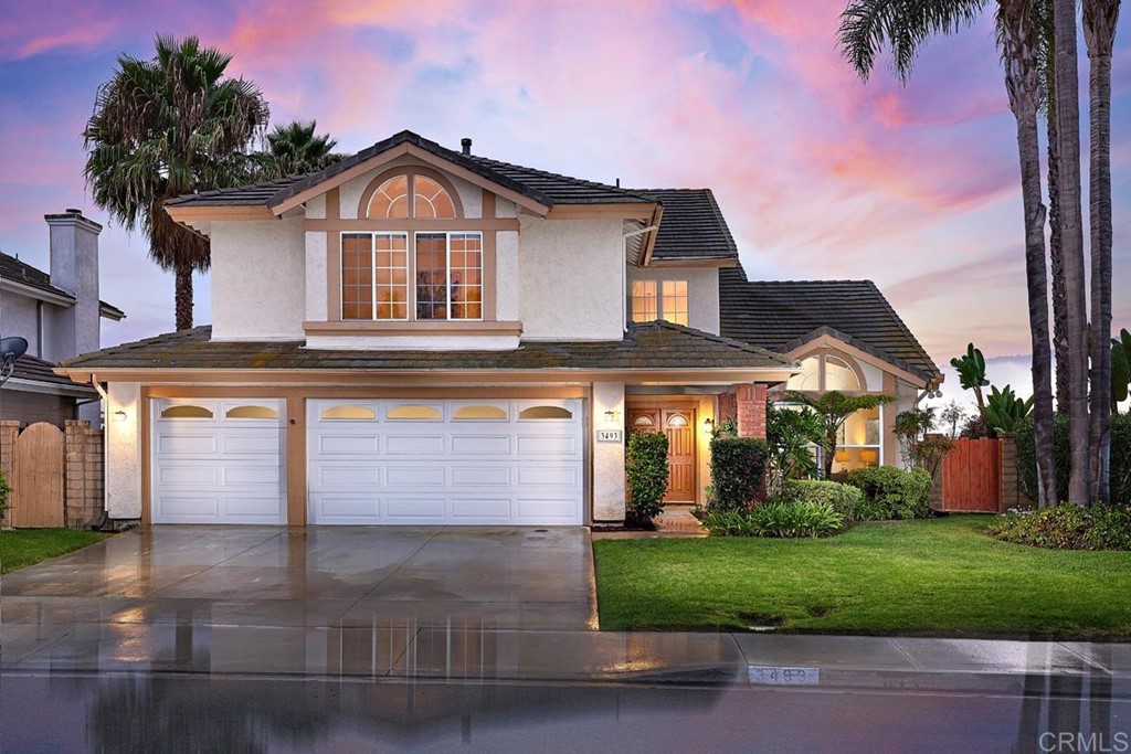a front view of a house with a yard and garage