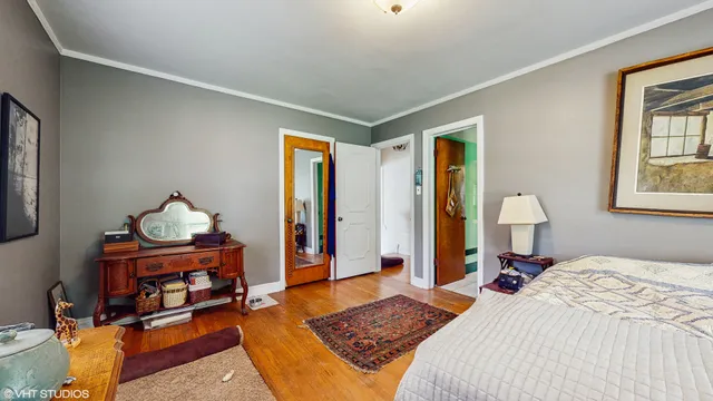 a bedroom with a bed and a dresser next to a window