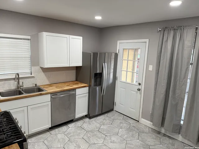 a kitchen with stainless steel appliances granite countertop a refrigerator and a sink