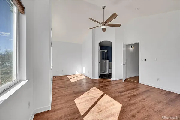 a view of empty room with wooden floor and window