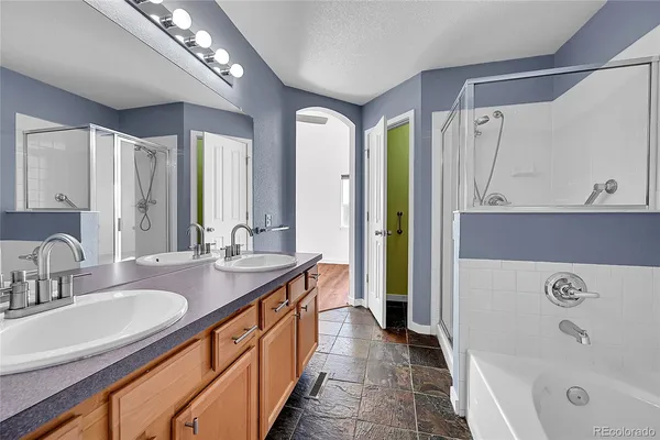 a spacious bathroom with a double vanity sink a mirror and a bathtub