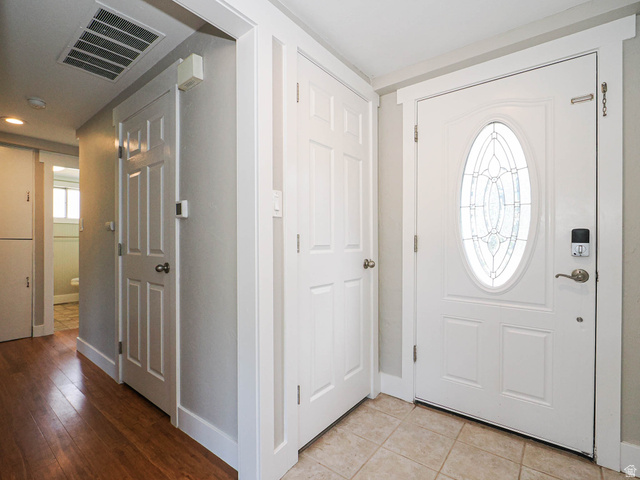 154 East 3000th Street South Bountiful, UT 84010 - Photo 6 of 37 Entryway featuring a white paneled door with an oval stained-glass insert, a digital lock, and tile flooring
