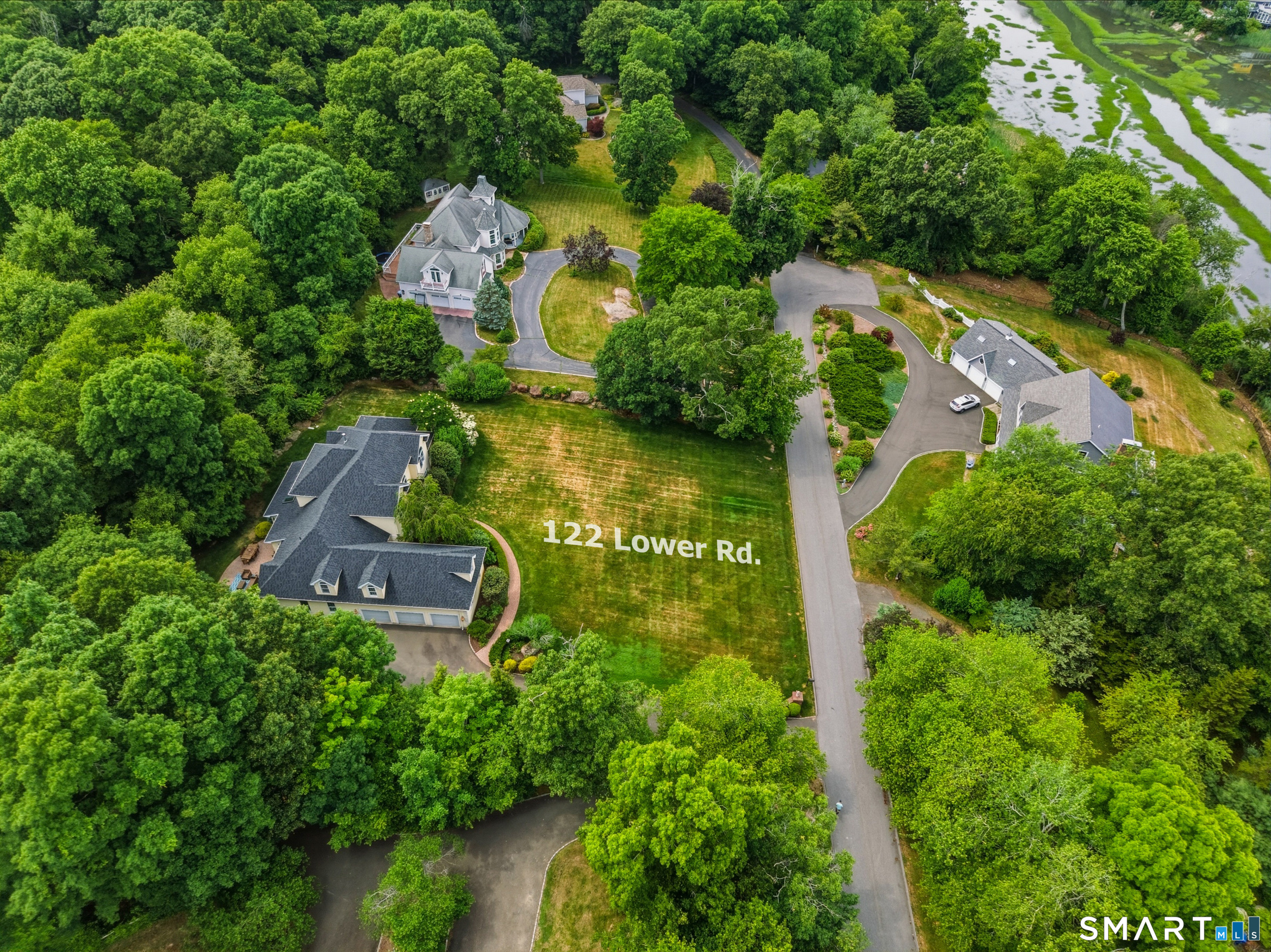 122 Lower Road Guilford, CT 06437 - Photo 34 of 40 Aerial view of the property showcasing the home, yard, surrounding neighborhood, and nearby salt marsh, highlighting the beautiful coastal setting and natural surroundings.