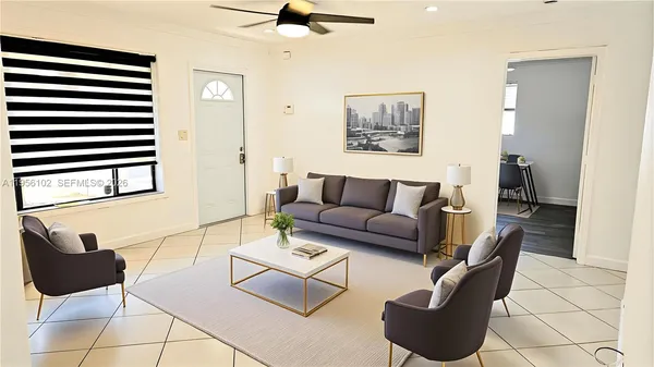 a living room with furniture and a black refrigerator