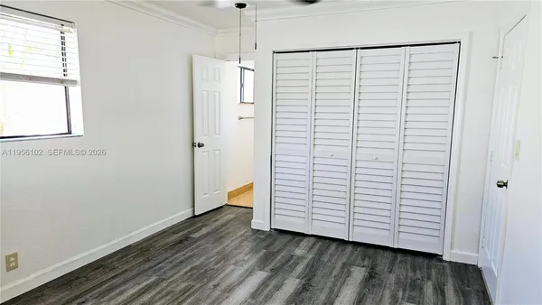 a view of a room with wooden floor closet and windows
