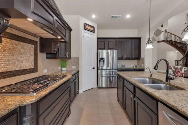 a kitchen with stainless steel appliances granite countertop a sink stove and refrigerator