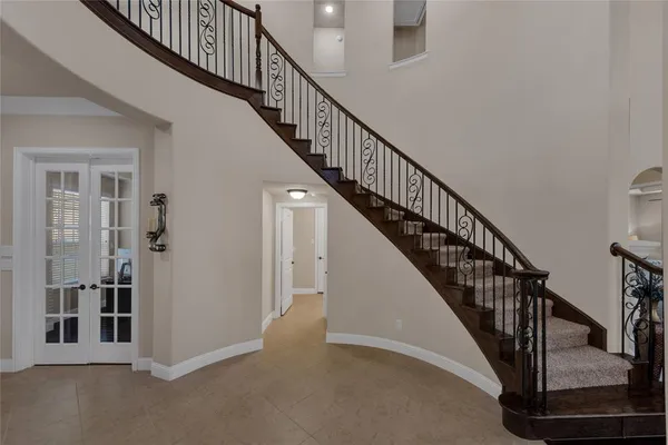a view of staircase with lots of frames on wall and windows