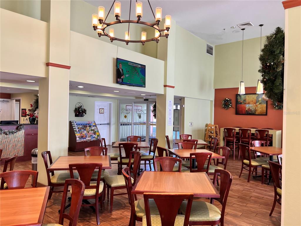 3000 Maingate Lane, Unit 506 Kissimmee, FL 34747 - Photo 15 of 18 a view of a dining room with furniture a chandelier and wooden floor