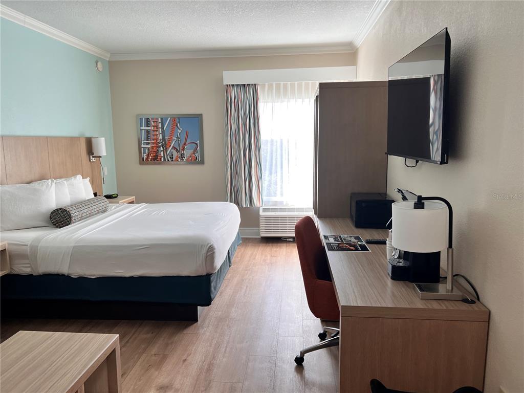 3000 Maingate Lane, Unit 506 Kissimmee, FL 34747 - Photo 4 of 18 a bedroom with a bed and wooden floor