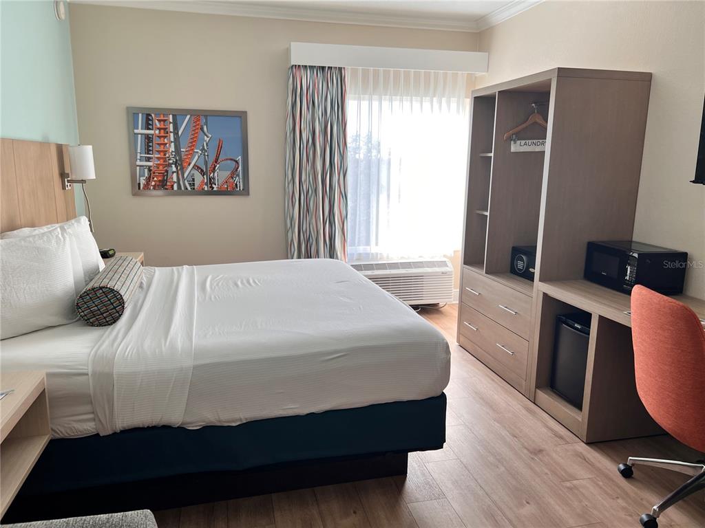 3000 Maingate Lane, Unit 506 Kissimmee, FL 34747 - Photo 9 of 18 a bedroom with a bed and wooden floor