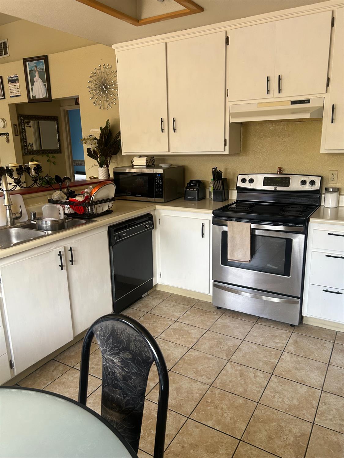 304 North Madison Street Modesto, CA 95351 - Photo 5 of 12 a kitchen with a stove a sink and a microwave