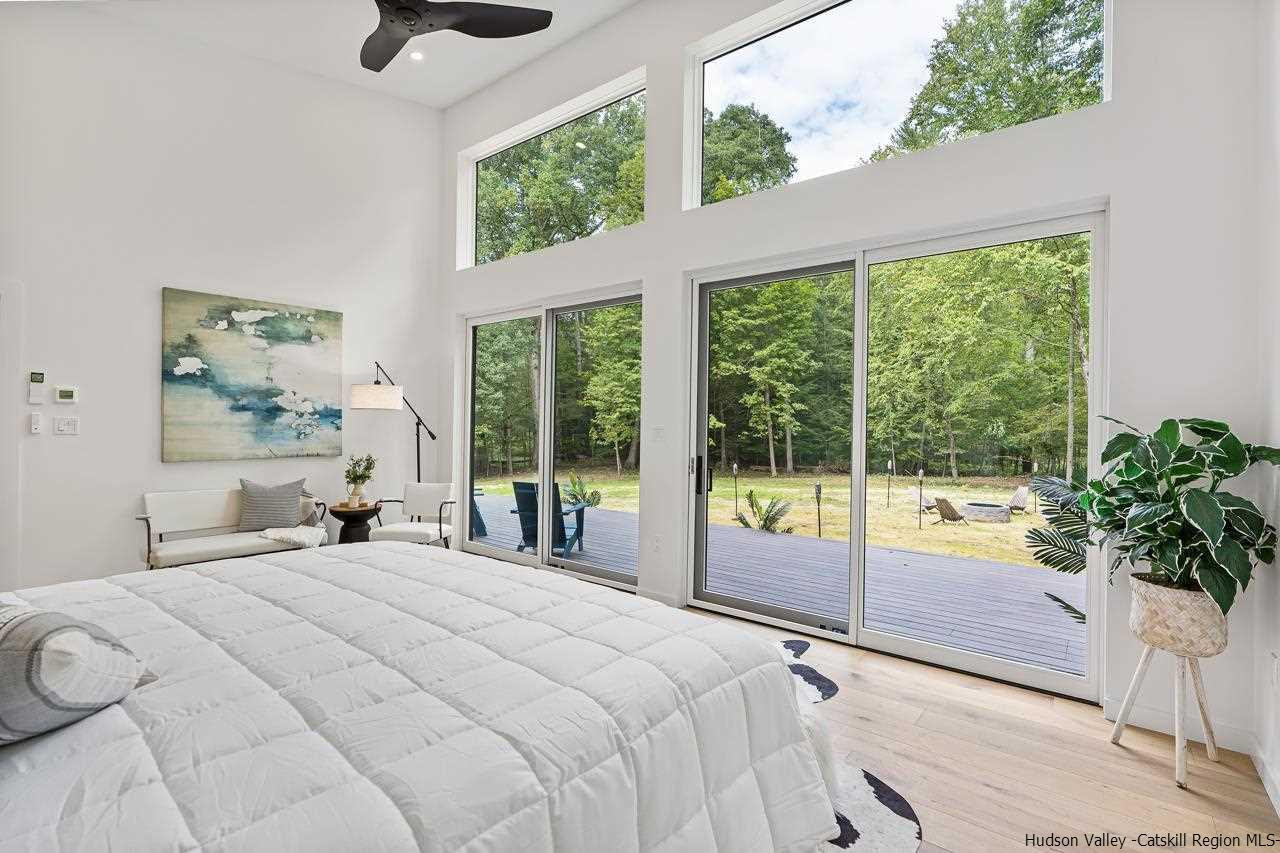 139 Krum Road Kerhonkson, NY 12446 - Photo 15 of 35 a bedroom with a large bed and a large window