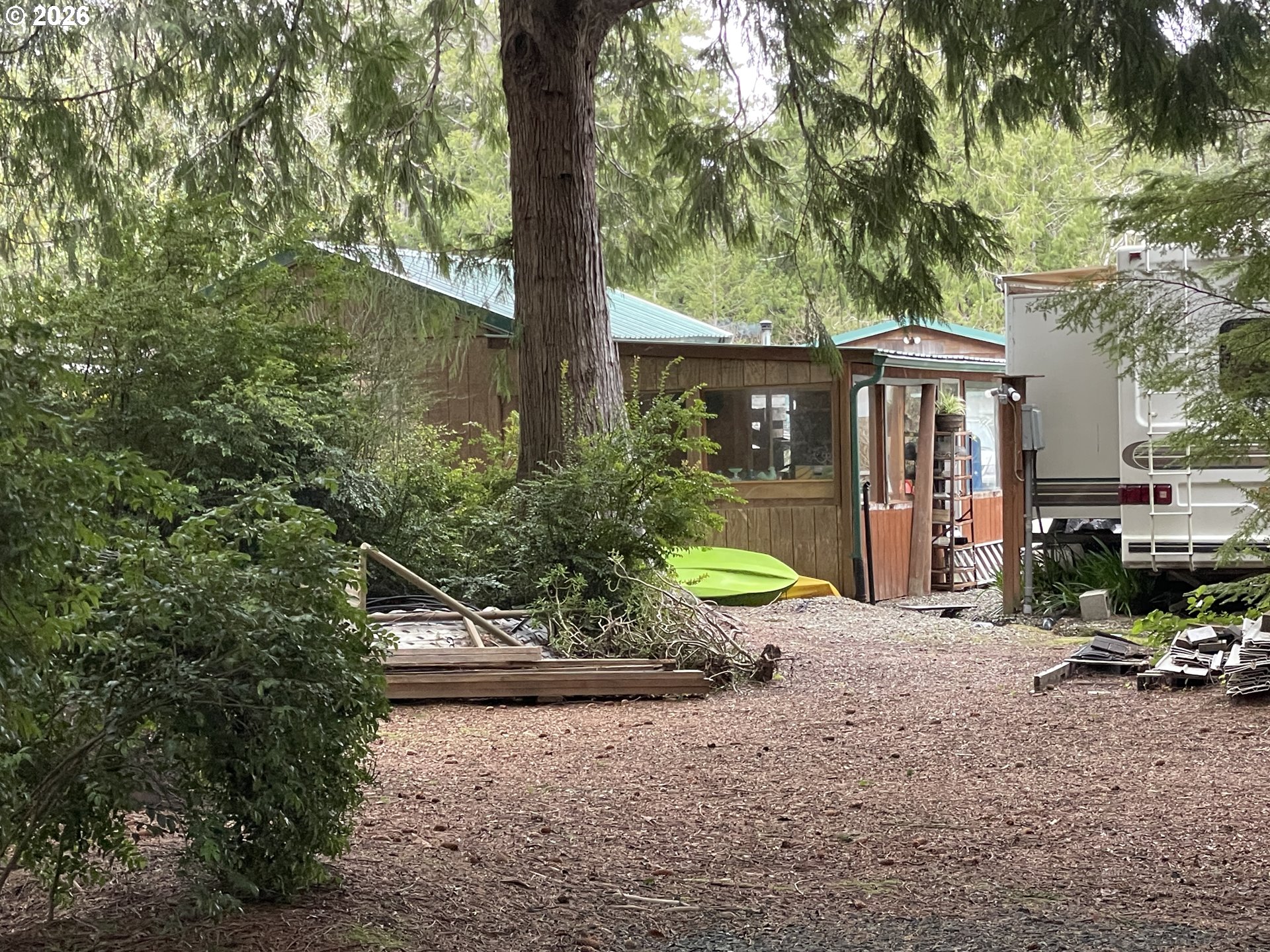Cozy Pines Bandon, OR 97411 - Photo 9 of 13 a view of a chair and table in backyard of the house