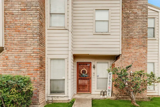 a front view of a house with a garden and plants