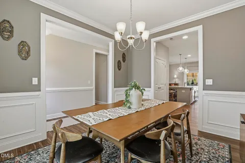 a kitchen with stainless steel appliances a table chairs and a refrigerator