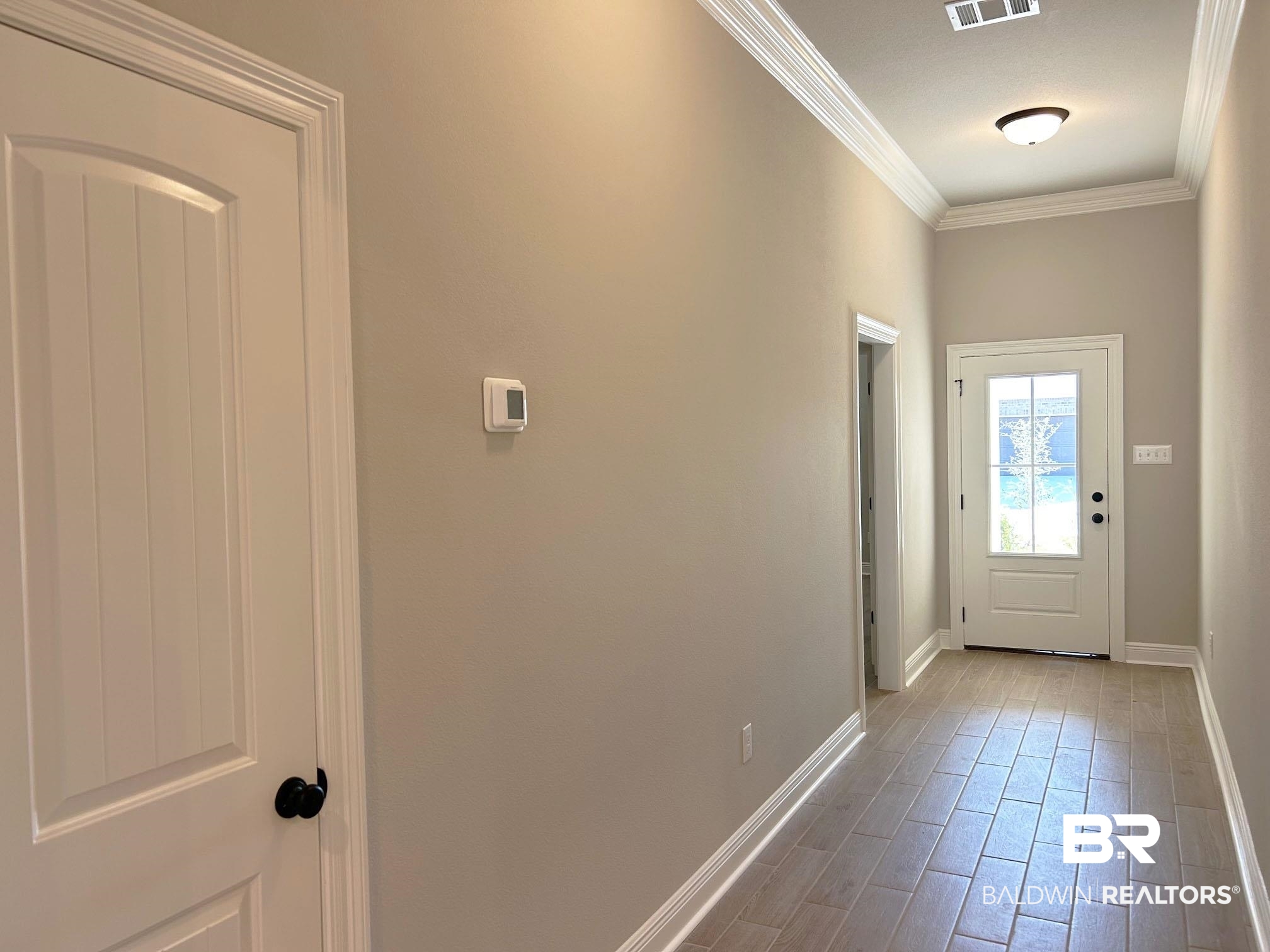 877 Sumter Loop Foley, AL 36535 - Photo 6 of 18 Entryway featuring visible vents, baseboards, wood finished floors, and crown molding