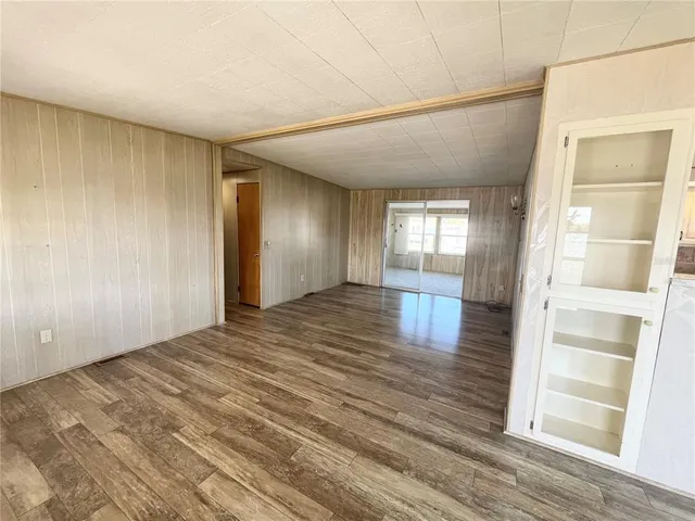 a view of an empty room with window and wooden floor