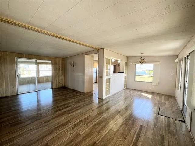 a view of empty room with wooden floor and window