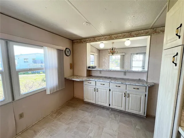 a spacious bathroom with a granite countertop sink mirror and a bathtub