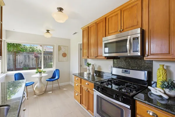 a kitchen with stainless steel appliances granite countertop a stove a sink dishwasher a microwave oven with granite countertops and cabinets
