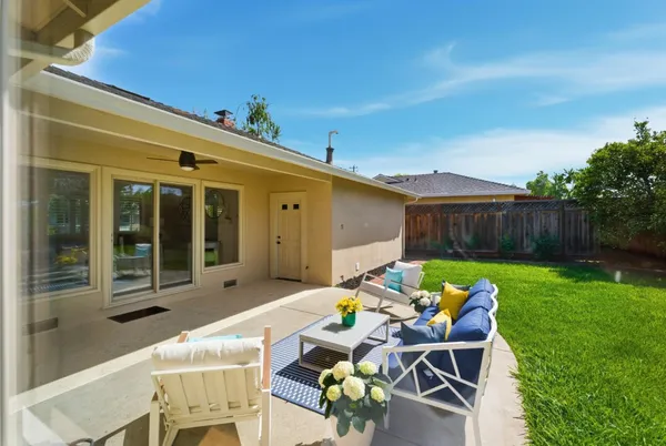 a view of a patio with table and chairs and potted plants