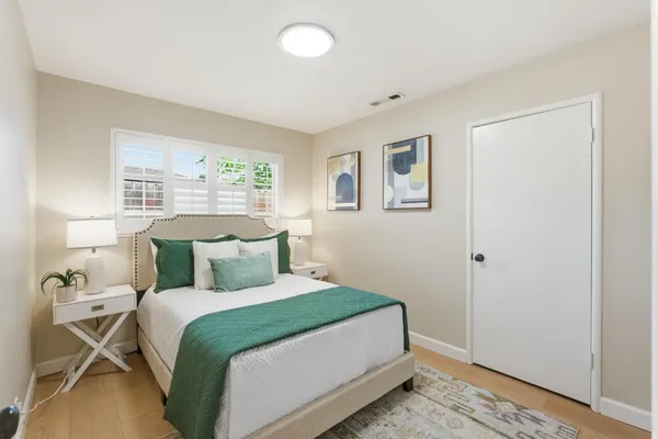 a bedroom with a bed and wooden floor
