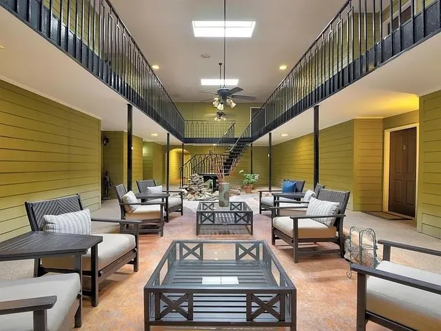 a living room with furniture a chandelier and a rug