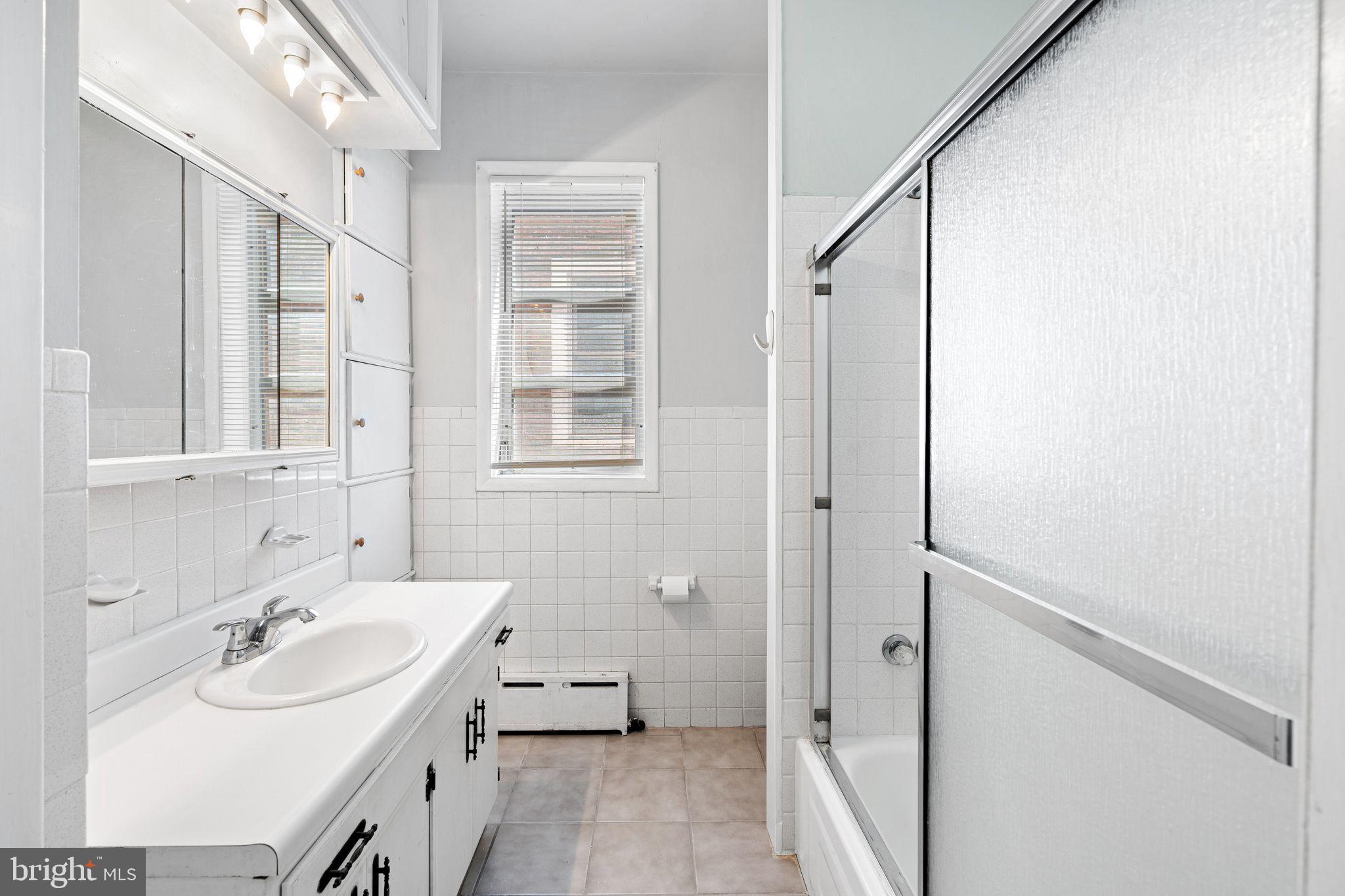 2324 Poplar Street, Unit 2F Philadelphia, PA 19130 - Photo 11 of 17 a bathroom with a sink a mirror and a shower