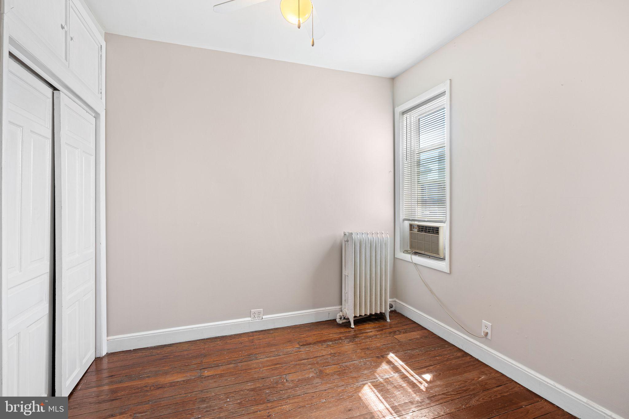 2324 Poplar Street, Unit 2F Philadelphia, PA 19130 - Photo 13 of 17 an empty room with wooden floor and windows