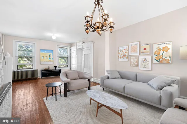 a living room with furniture a chandelier and a window