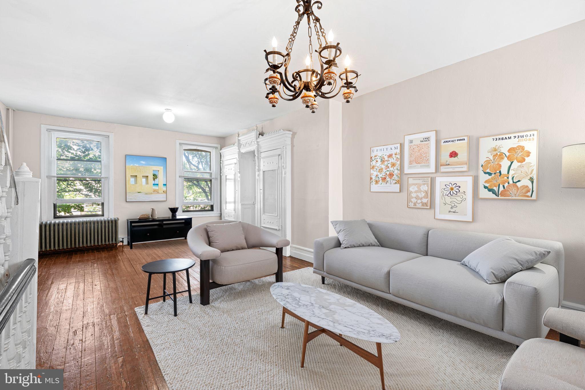 2324 Poplar Street, Unit 2F Philadelphia, PA 19130 - Photo 2 of 17 a living room with furniture a chandelier and a window