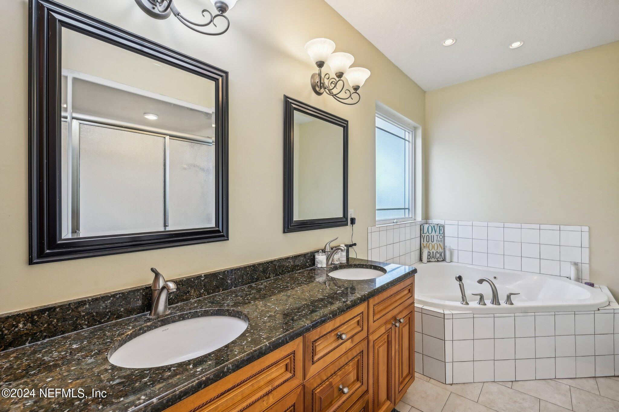 4253 Dalry Drive Jacksonville, FL 32246 - Photo 16 of 40 a bathroom with a granite countertop tub sink and mirror