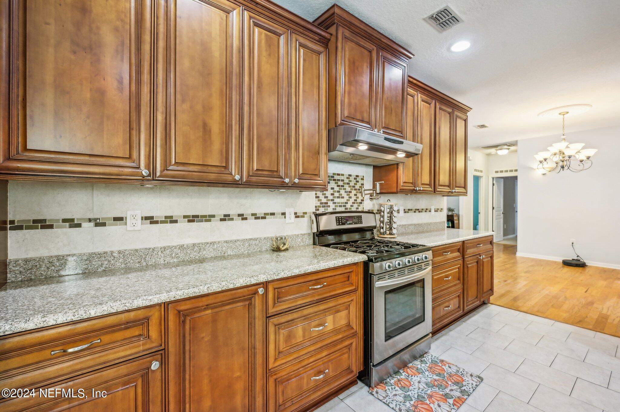 4253 Dalry Drive Jacksonville, FL 32246 - Photo 10 of 40 a kitchen with stainless steel appliances granite countertop a stove a sink and a granite counter tops