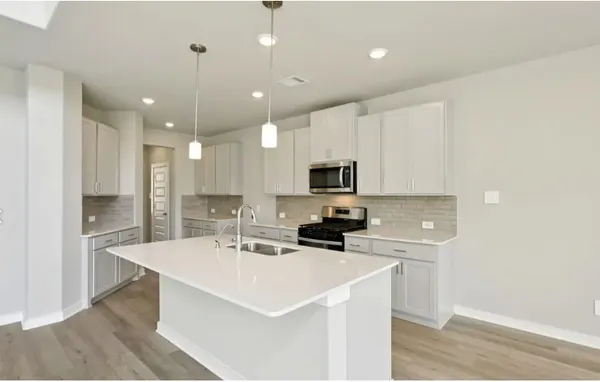 a kitchen with kitchen island a sink stainless steel appliances and white cabinets