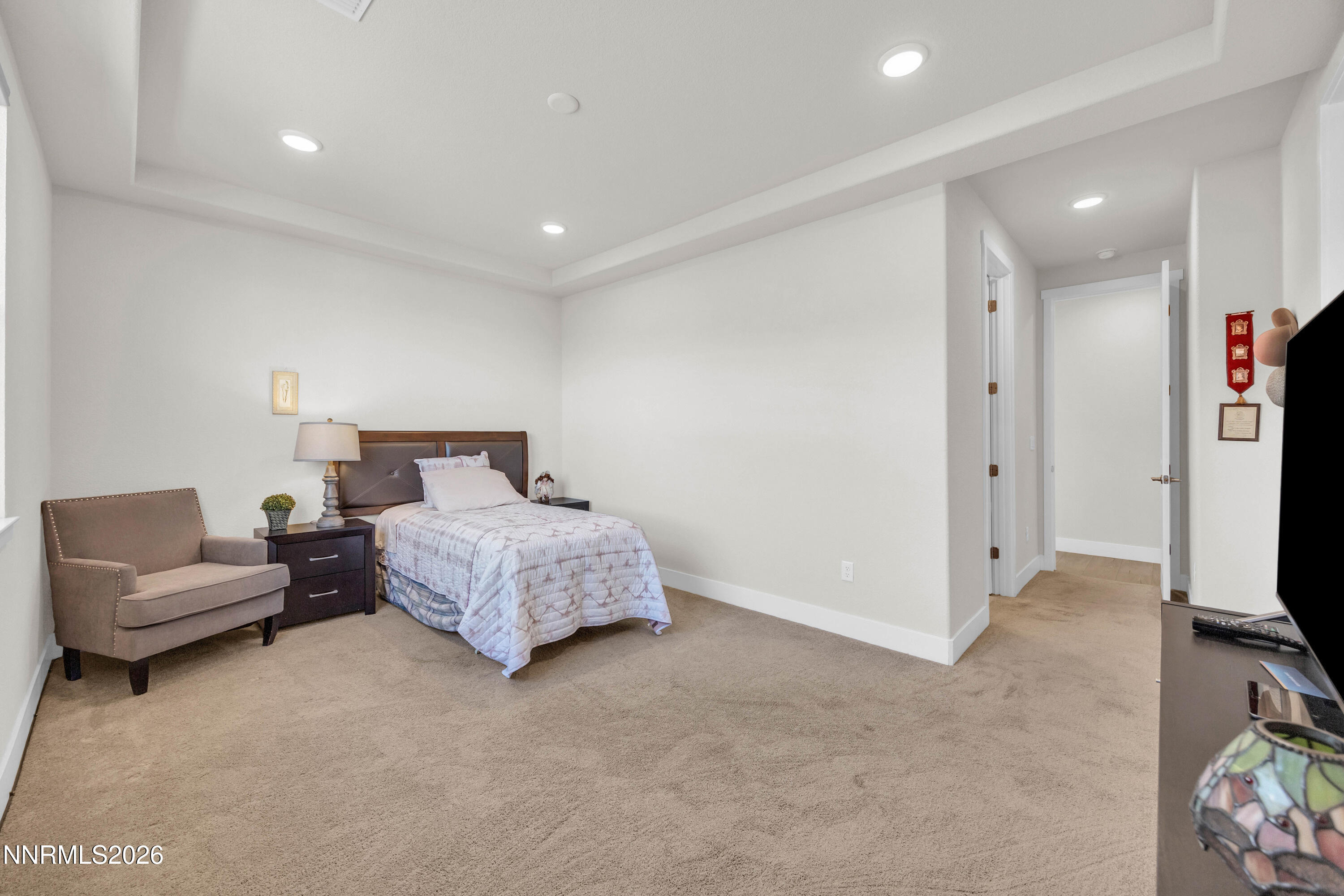 7774 Enclave Key Road Reno, NV 89506 - Photo 11 of 26 a bedroom with a bed flat screen tv and a couch