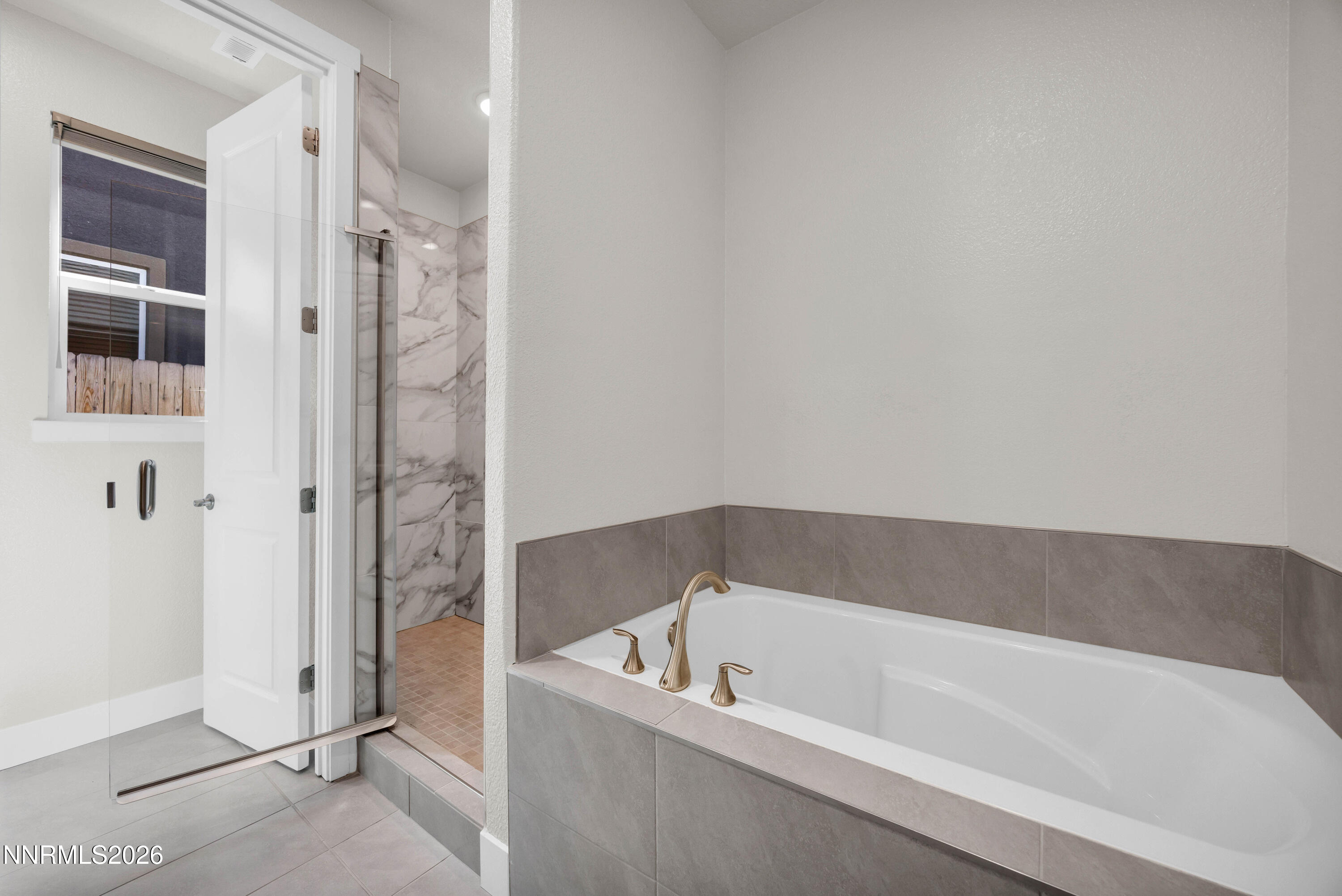 7774 Enclave Key Road Reno, NV 89506 - Photo 15 of 26 a bathroom with a bathtub and a shower