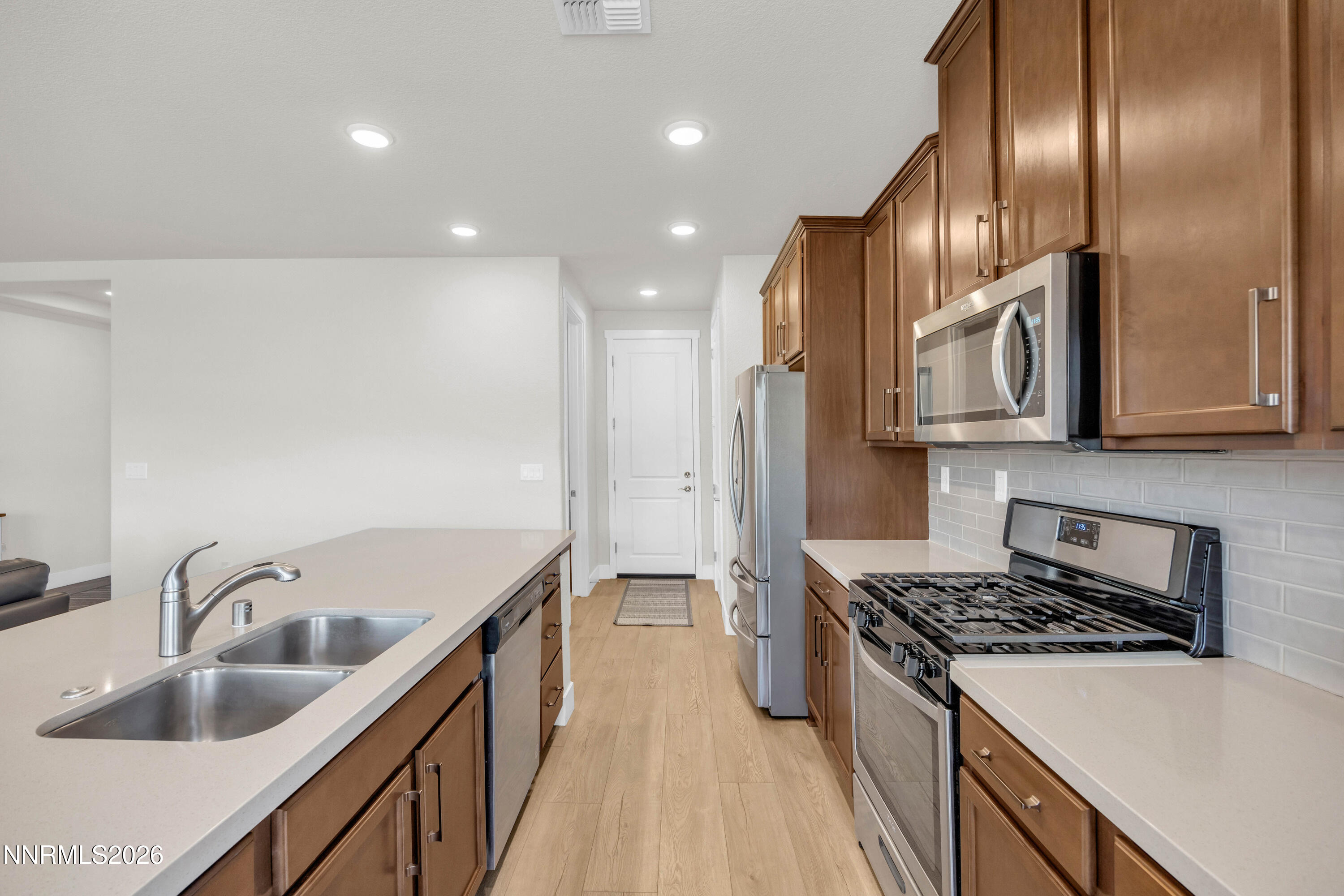 7774 Enclave Key Road Reno, NV 89506 - Photo 7 of 26 a kitchen with stainless steel appliances granite countertop a sink stove and refrigerator
