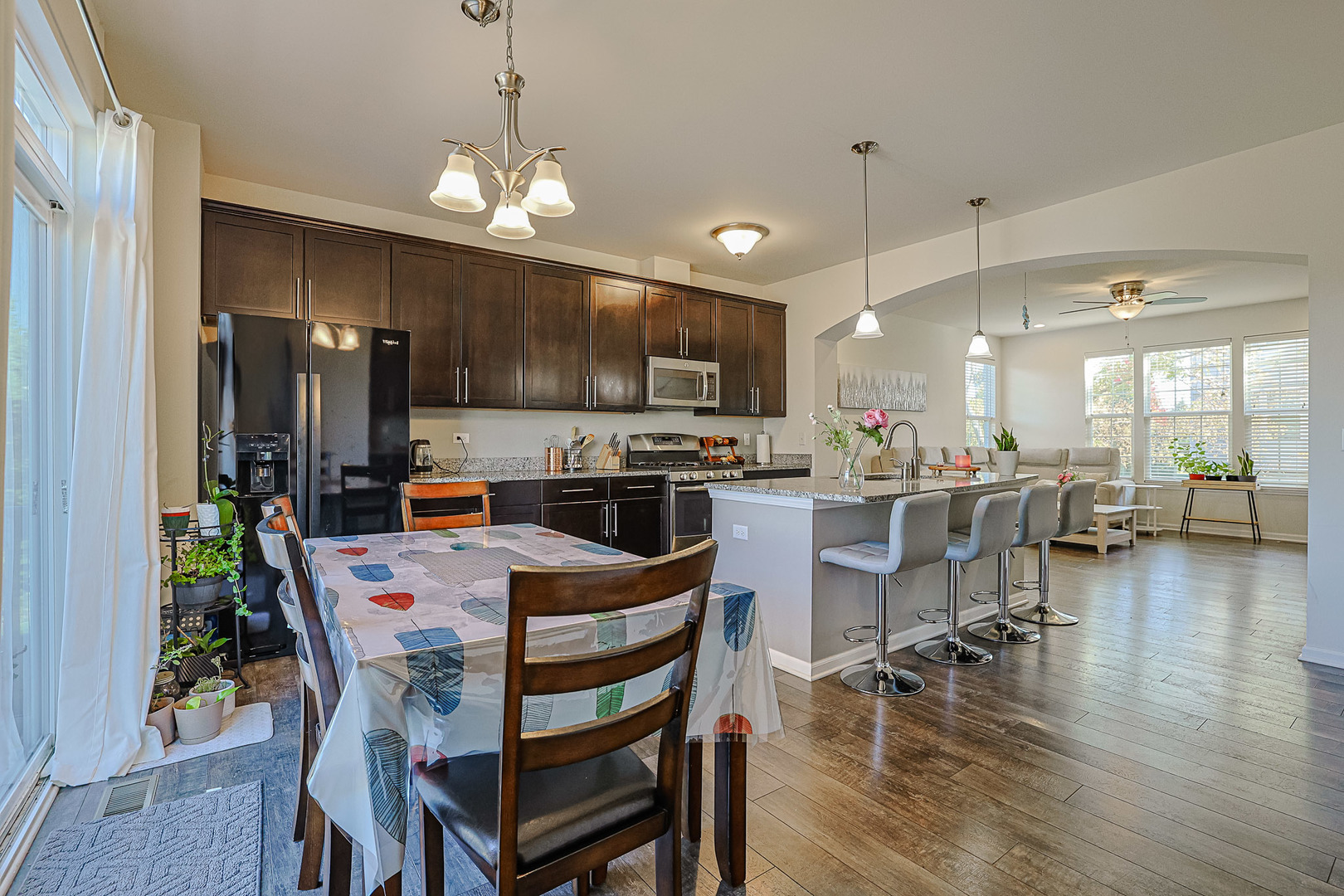 299 Bennett Drive Carol Stream, IL 60188 - Photo 11 of 27 a kitchen with stainless steel appliances a dining table chairs stove refrigerator and microwave