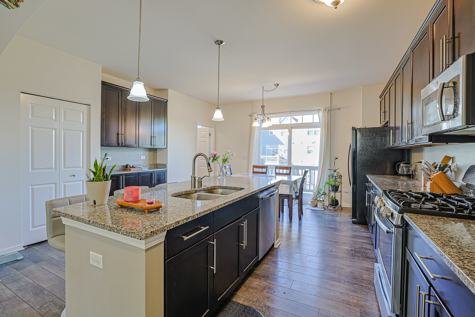299 Bennett Drive Carol Stream, IL 60188 - Photo 9 of 27 a kitchen with stainless steel appliances granite countertop a stove top oven a sink dishwasher and a refrigerator with wooden floor