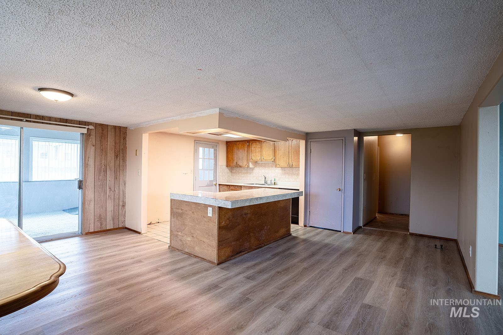 1357 Pound Lane Clarkston, WA 99403 - Photo 16 of 38 Kitchen with light countertops, a center island, light wood-type flooring, a textured ceiling, and wood finish cabinets
