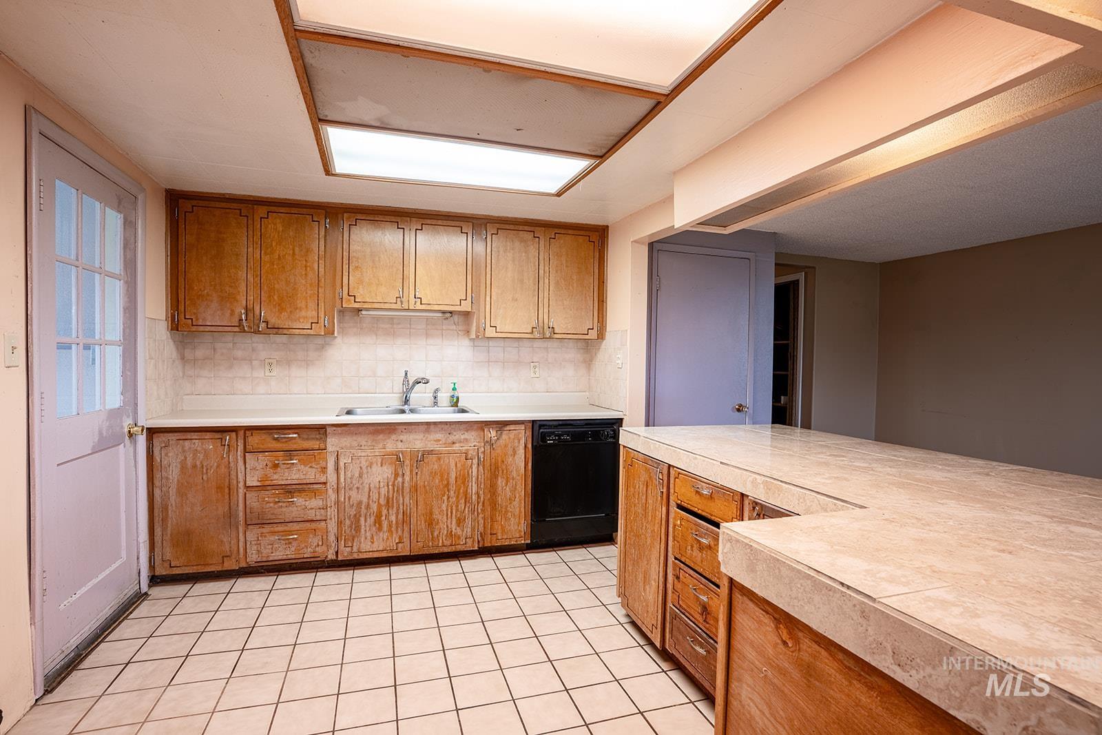 1357 Pound Lane Clarkston, WA 99403 - Photo 18 of 38 Kitchen featuring dishwasher, wood finish cabinetry, and light tile patterned floors