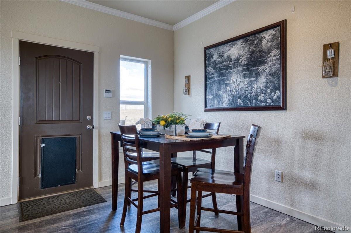 1215 North Yoder Road Yoder, CO 80864 - Photo 15 of 37 a view of a dining room with furniture and wooden floor