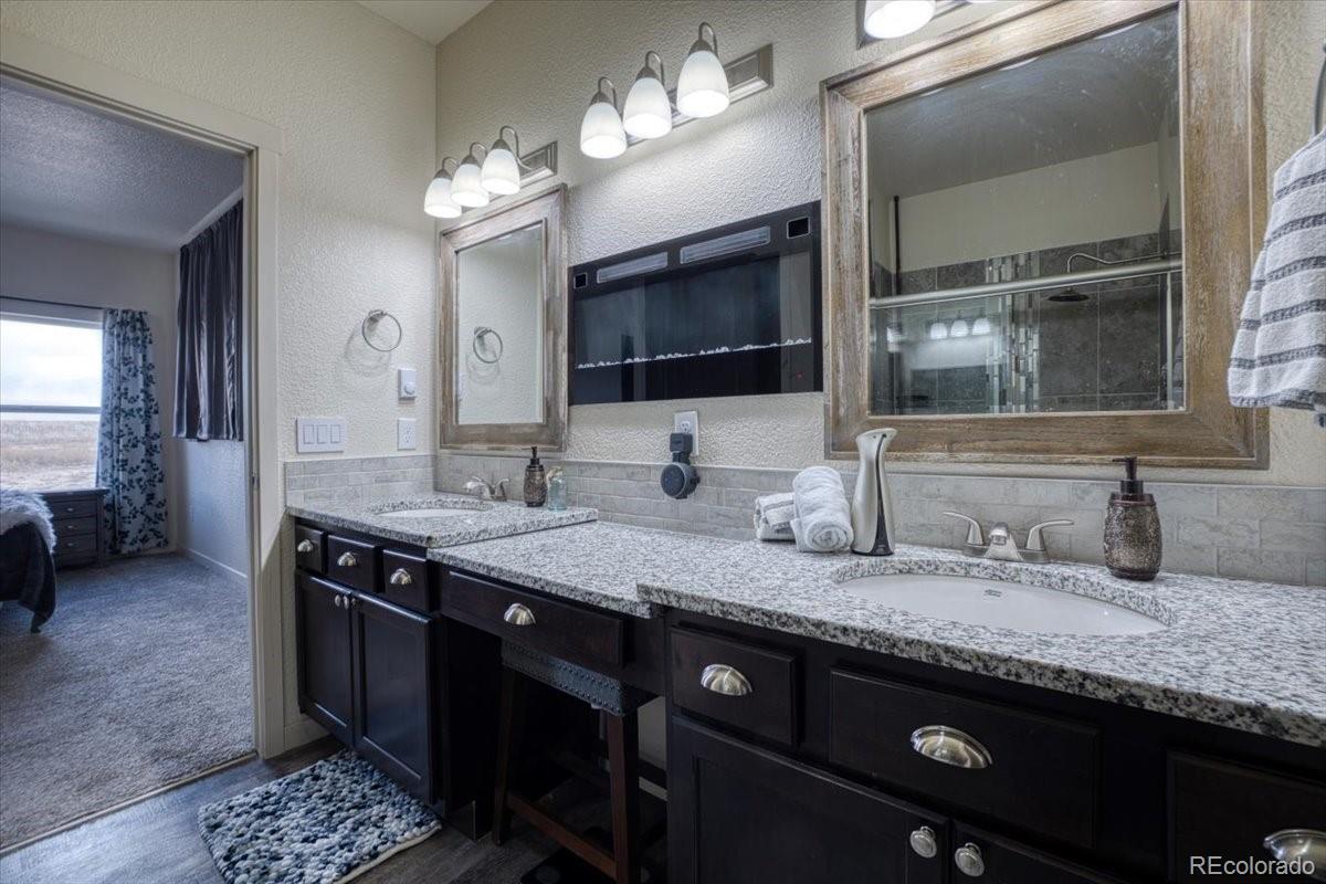 1215 North Yoder Road Yoder, CO 80864 - Photo 22 of 37 a bathroom with a granite countertop sink and a mirror