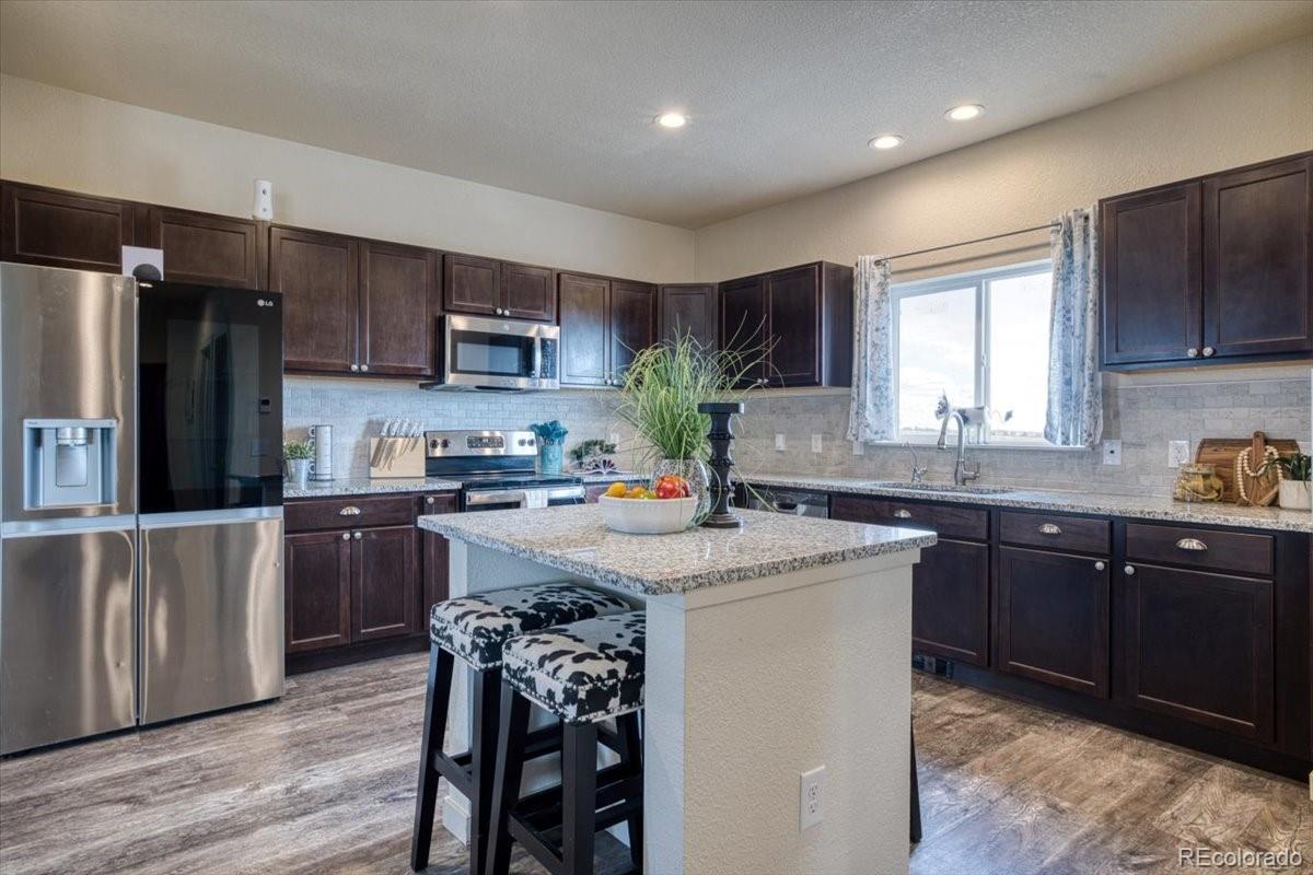1215 North Yoder Road Yoder, CO 80864 - Photo 7 of 37 a kitchen with a sink stove and refrigerator
