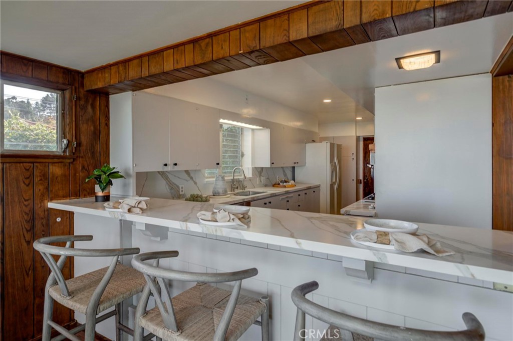 4612 Beauvais Road Rancho Palos Verdes, CA 90275 - Photo 17 of 40 a kitchen with a sink stools a counter space and cabinets