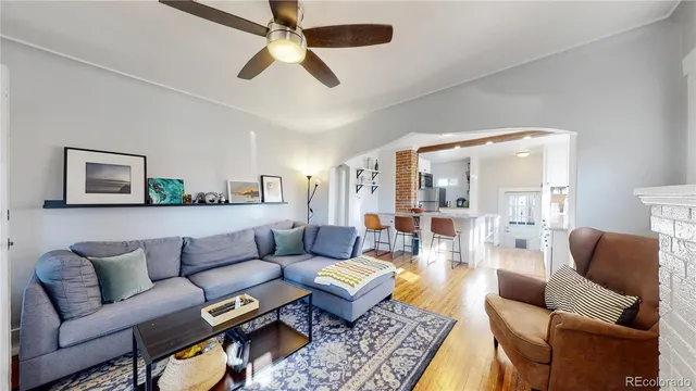 a living room with furniture a ceiling fan and a rug