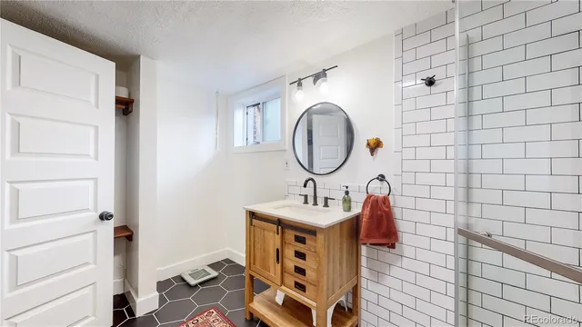 a bathroom with a sink a mirror and shower