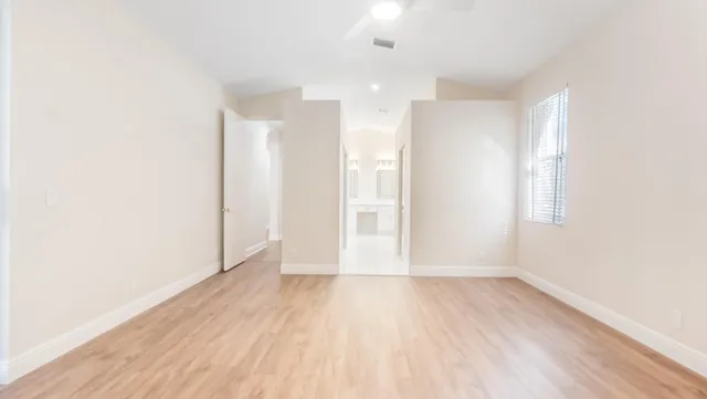a view of an empty room with wooden floor