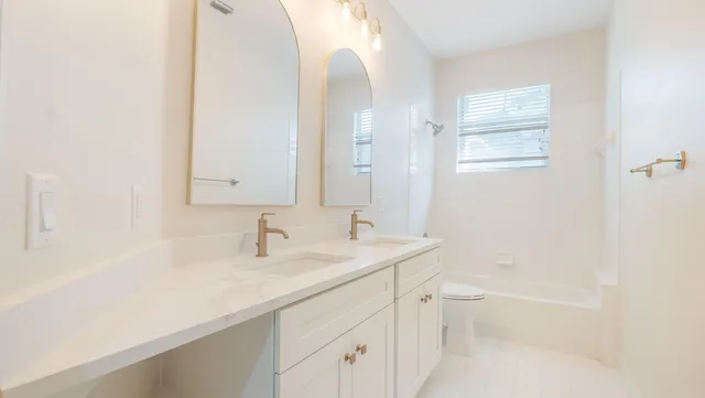 a bathroom with a sink a toilet and a mirror