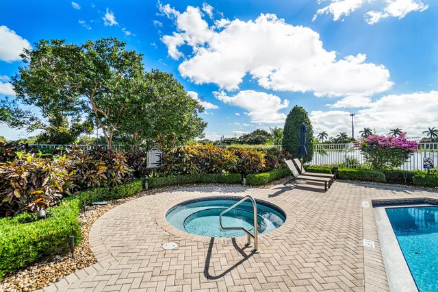 a view of a swimming pool with a patio and plants